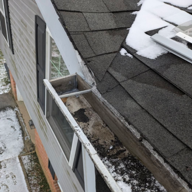 Heavy shingle grit and sediment buildup in gutters after a severe winter storm in Powell, Ohio.